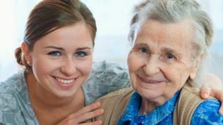 Younger person helping elderly woman.