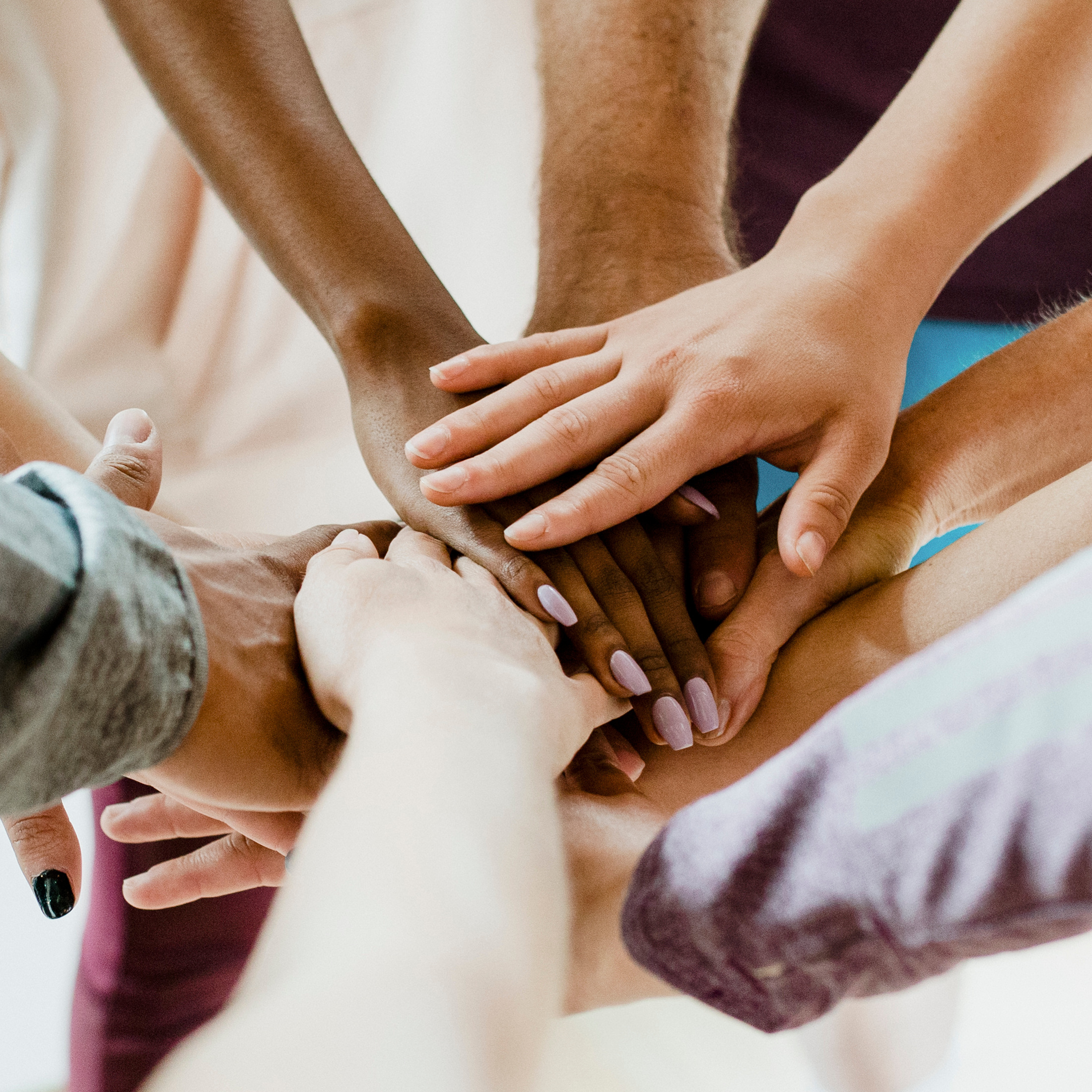 Group of diverse people stacking hands in the middle