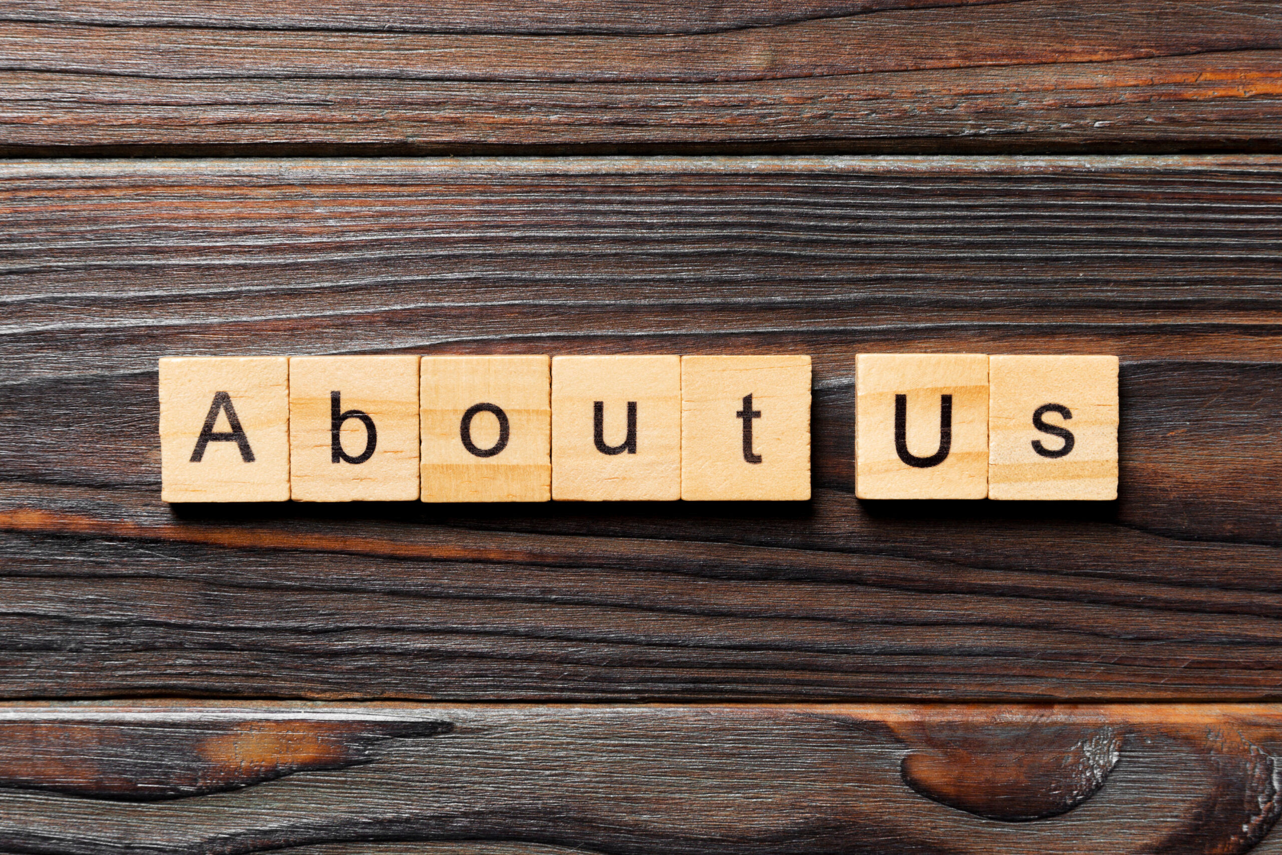 About us word written on wood block. About us text on wooden table